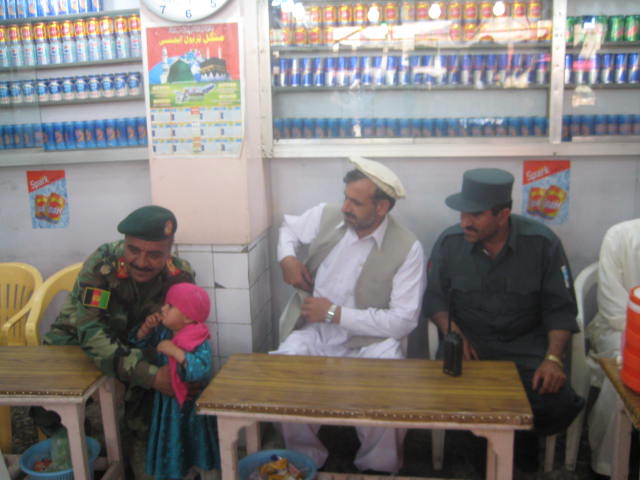 An ANA brigade commander, the governor of Khost, and the Khost police chief with a young girl in a downtown Khost ice cream shop.